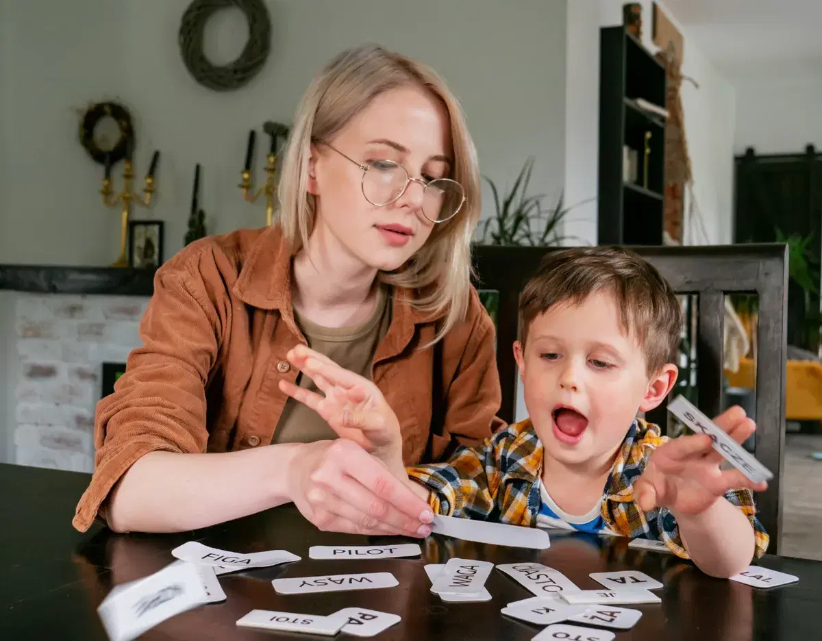 An adult and child practicing words with picture cards