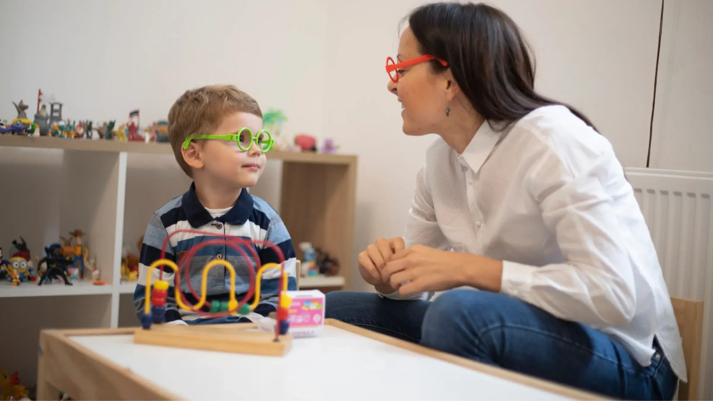 A clinician talking with a child during a therapy session